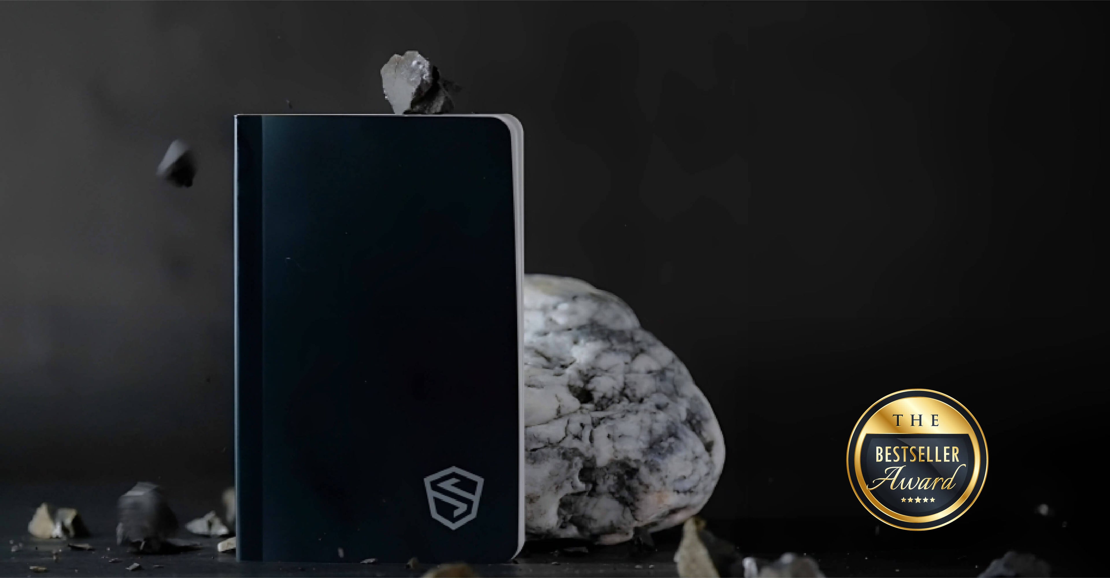 The Stonebook seed phrase notebook with rocks falling on top of it.